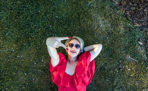 istock Smiling young woman lying on the grass 1488644538