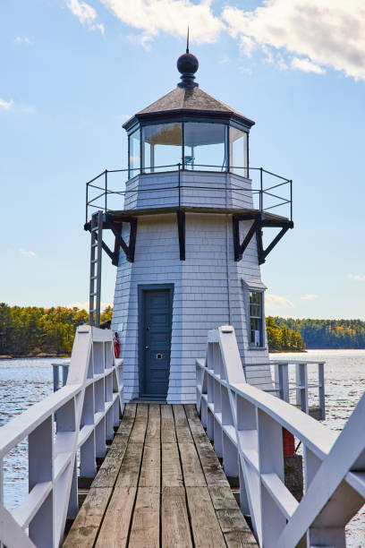 istock Boardwalk with railing leads to small white lighthouse on Maine river.jpg 1488645765