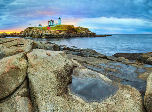 felsbrocken und pfützen der küste von maine mit blick auf den atemberaubenden leuchtturm von maine im morgenlicht.jpg - maine lighthouse york maine new england stock-fotos und bilder