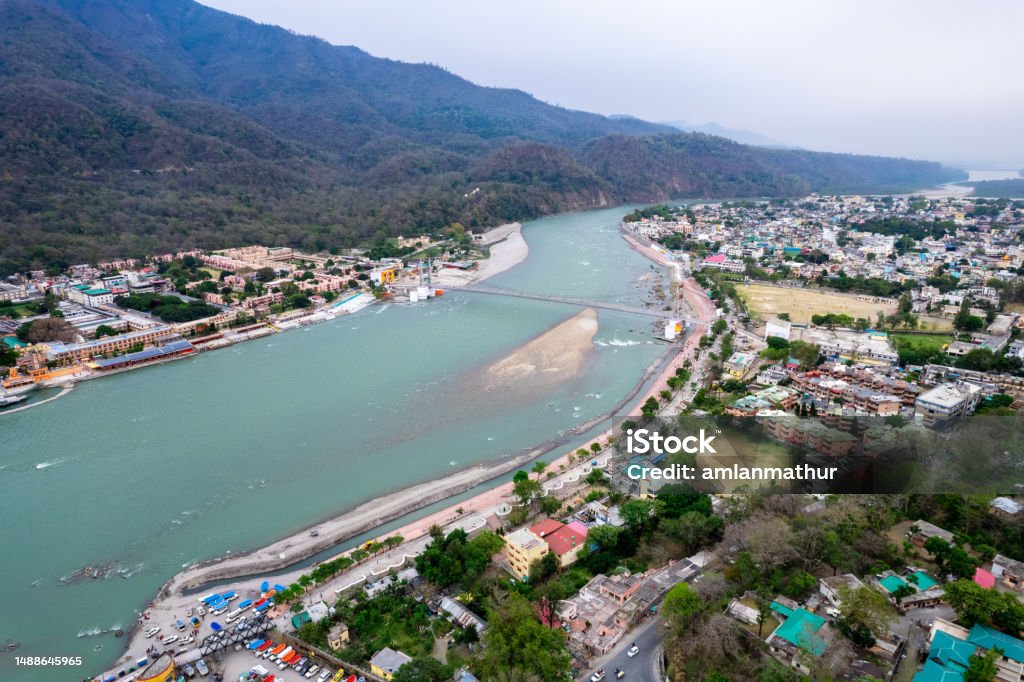 aerial drone shot over ram setu jhula suspension bridge with temples on the bank of river ganga in the holy spiritual city of Rishikesh Haridwar uttarakhand aerial drone shot over ram setu jhula suspension bridge with temples on the bank of river ganga in the holy spiritual city of Rishikesh Haridwar uttarakhand india Aerial View Stock Photo