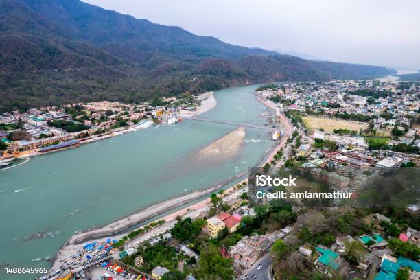 Aerial Drone Shot Over Ram Setu Jhula Suspension Bridge With Temples On The Bank Of River Ganga In The Holy Spiritual City Of Rishikesh Haridwar Uttarakhand Stock Photo - Download Image Now