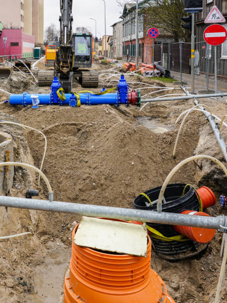istock Underground pipe replacement pit on city street, plastic wells, new pipeline with gate valves 1488647559