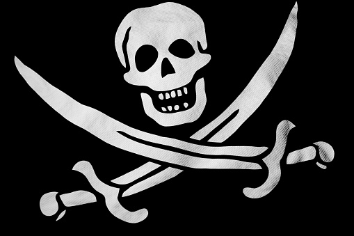 Full frame close-up on a waving Jolly Roger flag in 3D rendering.