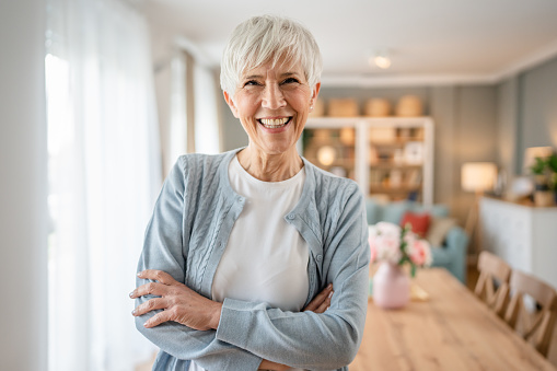 Close up portrait of one senior woman with short hair happy smile positive emotion copy space standing at home indoor gray white hair