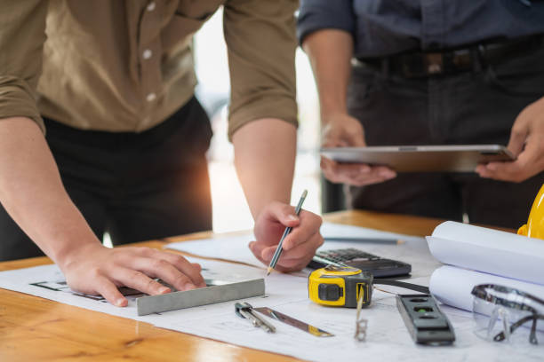 istock Asian engineers brainstorm and measure to document cost estimates and write floor plans for architectural and engineering designs for houses and buildings. 1488654178