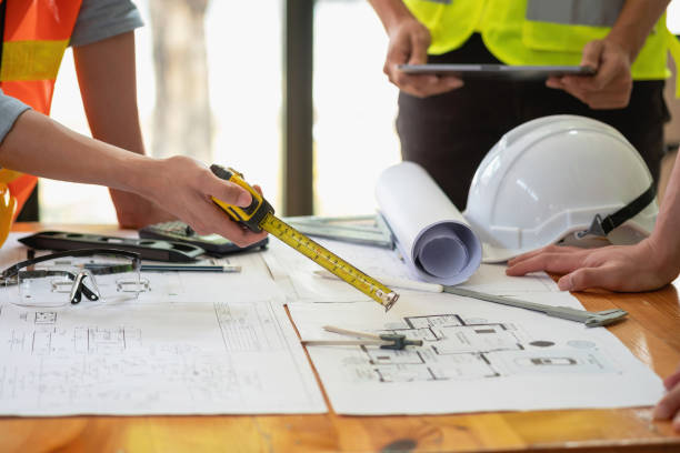istock Asian engineers brainstorm and measure to document cost estimates and write floor plans for architectural and engineering designs for houses and buildings. 1488654858