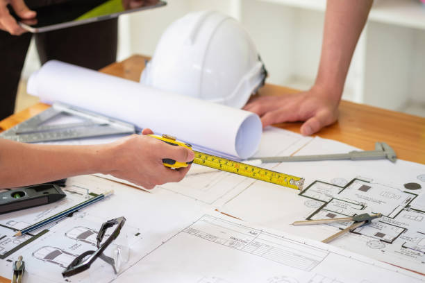 istock Asian engineers brainstorm and measure to document cost estimates and write floor plans for architectural and engineering designs for houses and buildings. 1488654903