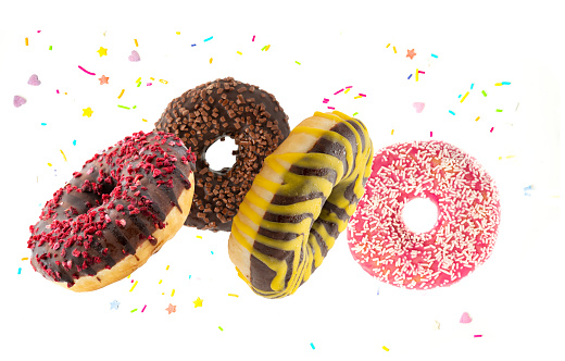 Flying donuts. Multicolored doughnuts with sprinkel on white background.