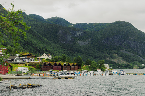 Dramatic view of small authentic town in the green summer mountains by the sea in Western Norway, Scandinavia