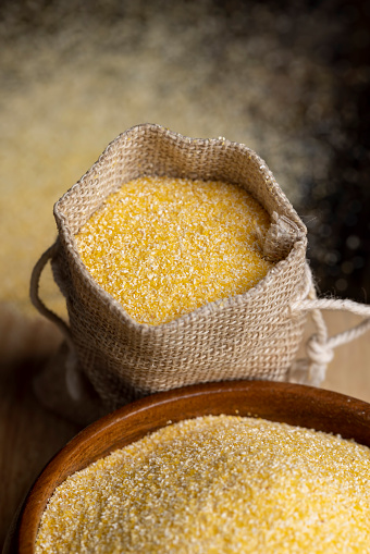Dry corn flour poured into a linen bag for making porridge, high-quality corn flour from corn grains in a bag