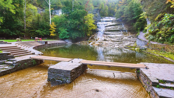 Huge waterfall terracing down into river with walking bridge and seating area.jpg