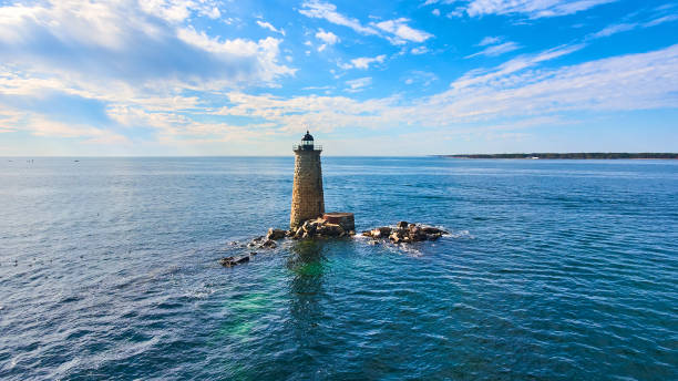 メイン州の崩壊した岩の瓦礫を持つ水の真ん中にある孤独な石の灯台塔.jpg - maine lighthouse rock sea ストックフォトと画像