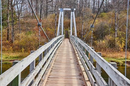 Image of Looking down large suspension bridge over river in Michigan park