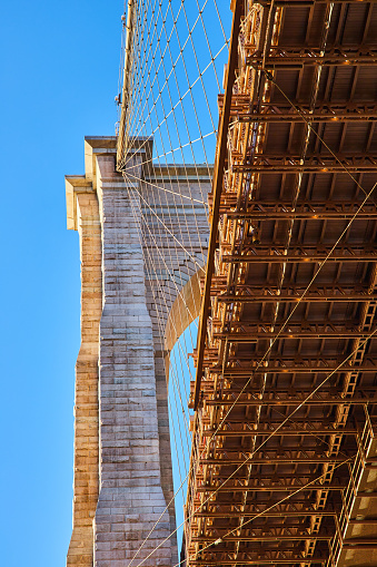 Image of New York City Brooklyn Bridge from below with dozens of webbing-like wires for support