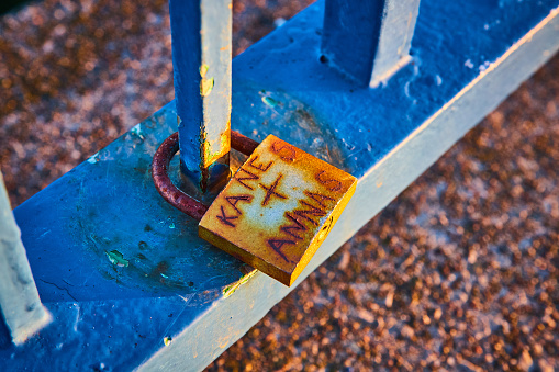 Rusty lock on blue railing with Kane + Anna carved on.jpg
