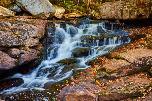 istock Small cascading river with rocks covered in fall leaves and tiny rock stack by edge.jpg 1488667503