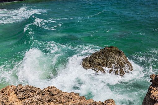 Beautiful view of foamy waves between big rocks. Natural backgrounds concept. Aruba.