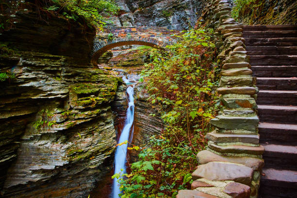 Image of Stone steps along gorge with stone arch walking bridge and waterfalls through gorge in Upstate New York