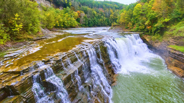istock Up close with drone to beautiful waterfall eroding cliffs with colorful forests around.jpg 1488668878