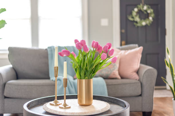 Home interior decorated for spring with stylish gold candlesticks and a vase of pink tulips