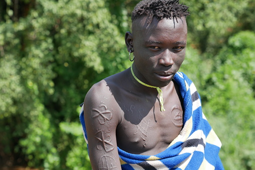 Omo Valley, Ethiopa – 11.17.2022: Young Mursi man with decorated skin