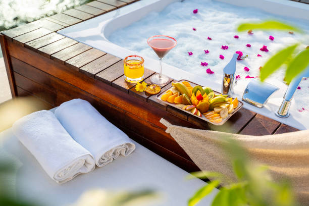 Pool Cocktails with fruit platter placed next to a spa's rooftop  bathtub stock photo
