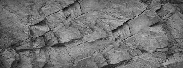 istock Black white. Rock texture. Cracked mountain surface. Close-up. 3d. Gray stone granite basalt background. Wide banner. 1488691209