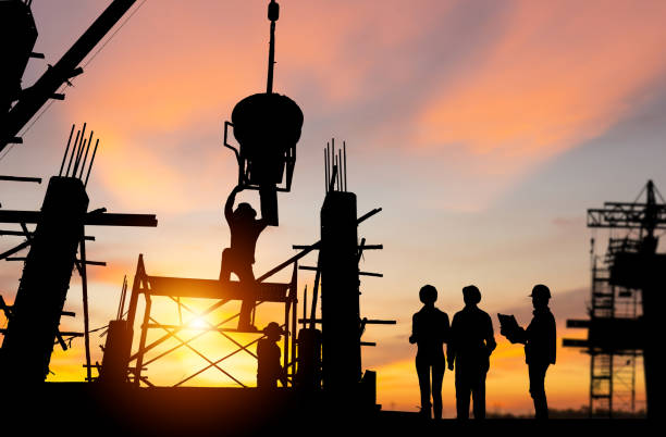 istock Silhouette of Engineer and worker team checking project at building site background, construction site with sunset in evening time background 1488692488