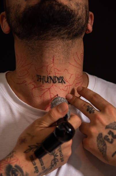 istock Professional tattooer doing tattoo on hand using tattoo machine in studio 1488693020