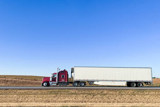 州間高速道路70号線の右揃えの栗色と白のセミトラックがコピースペースでカンザス州を西に走る - 4681 ストックフォトと画像