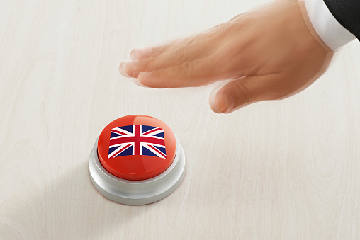 Businessman pushing a button with UK flag