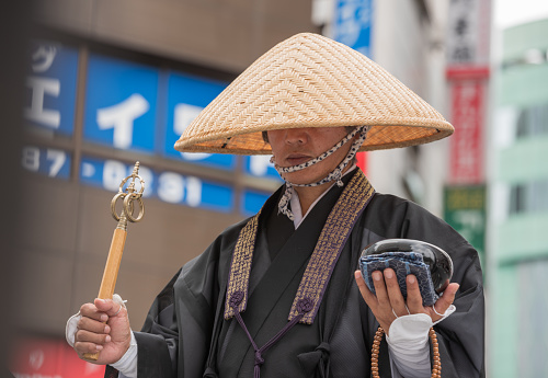 Tokyo, Japan - July 15, 2016: Buddhist monk, wearing  tengai, Kasa straw hat, that obliterates ego.