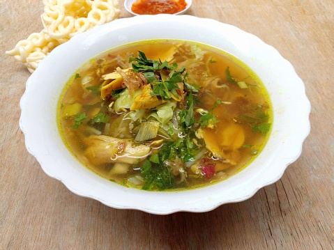 Indonesian soup made from chicken broth and turmeric seasoning served with additional slices of chicken meat, bean sprouts and vermicelli.