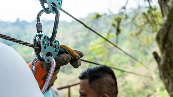 Tourist preparing harnesses to launch for a canopy in front of a waterfall in Matagalpa, Nicaragua, Centroamerica