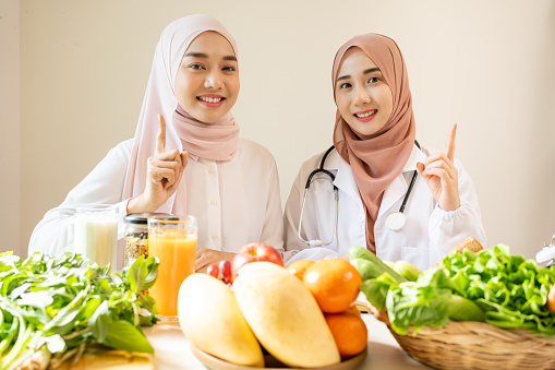 Asian Muslim nutritionists working advise nutrition for patient number one for services.