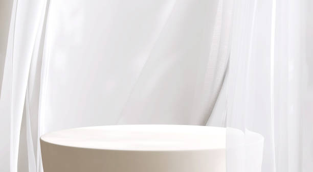 istock Empty clean, smooth, minimal, modern ivory cream round stone podium, white soft blowing sheer curtain in sunlight on beige wall 1488734886