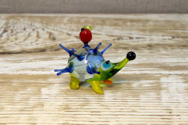 istock Miniature glass hedgehog figurine on wooden rough surface 1488748683