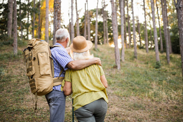 istock Back of an elderly couple during their hike with backpacks 1488748989