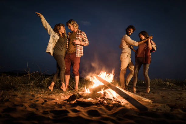 istock Two happy couples dancing on a night party by the campfire. 1488763237