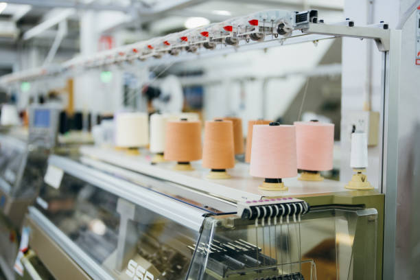 istock Image of spools of multicolored sewing threads lined up on a weaving machine in the sewing industry to wait for the production of clothes for customer orders 1488763851