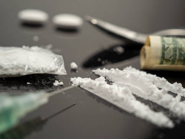 istock Syringe for injection and cocaine powder, on a black background. 1488765861