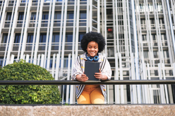 istock happy afro woman using tablet, view from below, modern background 1488766120