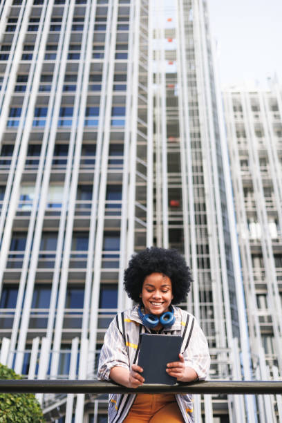 istock happy afro woman using tablet, view from below, modern background 1488766724