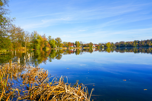 Wesslinger See in Wessling in the district of Starnberg in Bavaria. Autumn landscape by the lake. Idyllic nature.