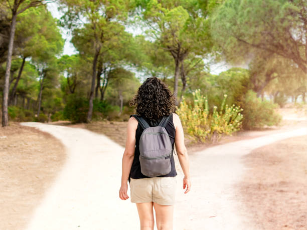 istock Woman choosing to take a light path or a dark path in a forest. Concept of decision making in life. 1488770226