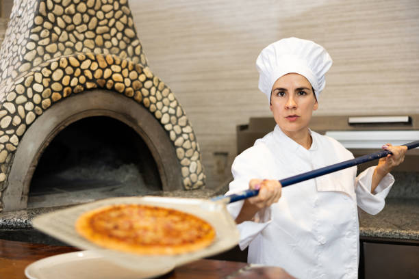 istock Woman pizza chef at work in restaurant 1488770458