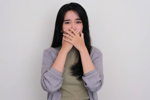 istock Asian young woman covering her mouth with hand showing scared expression 1488771592