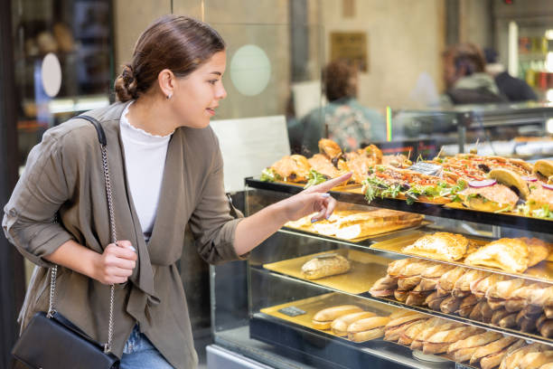 istock Young woman chooses fresh pastries in bakery 1488772793