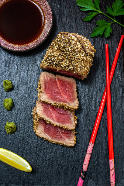 detalle de atún ahi chamuscado con sésamo sobre pizarra negra - tuna tuna steak raw freshness fotografías e imágenes de stock