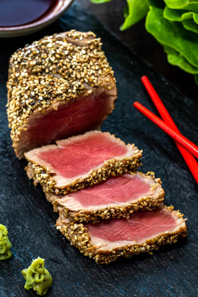gros plan vertical d’appétissant steak de thon en croûte de sésame - tuna tuna steak raw bluefin tuna photos et images de collection